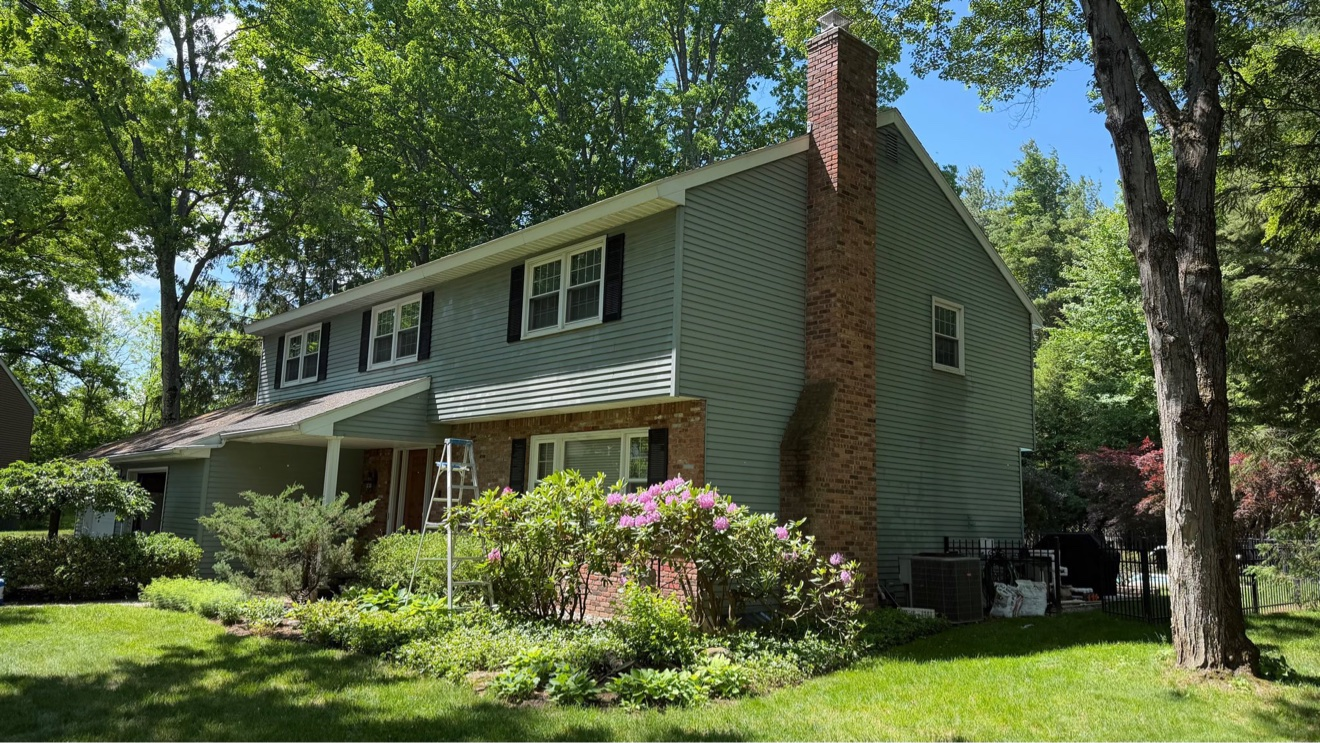 Before photo of the Exterior Repaint in Delmar, NY — front angle view with green siding before painting